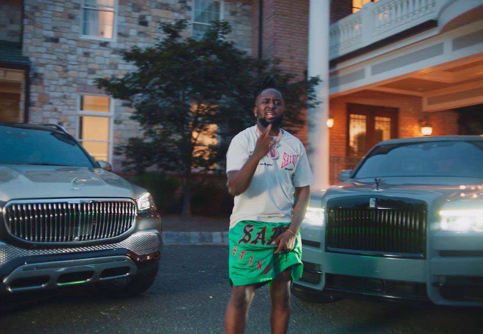 a man standing in front of a car talking on a cell phone