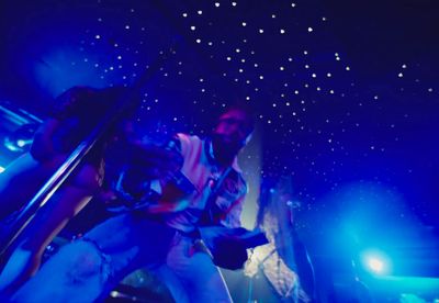 a man standing on a stage in front of blue lights