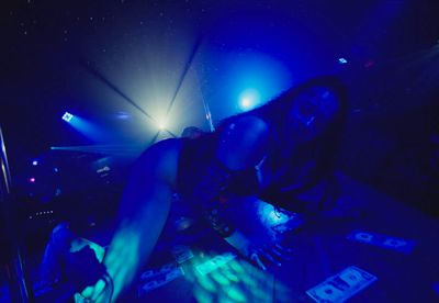 a woman in a dark room with blue lights