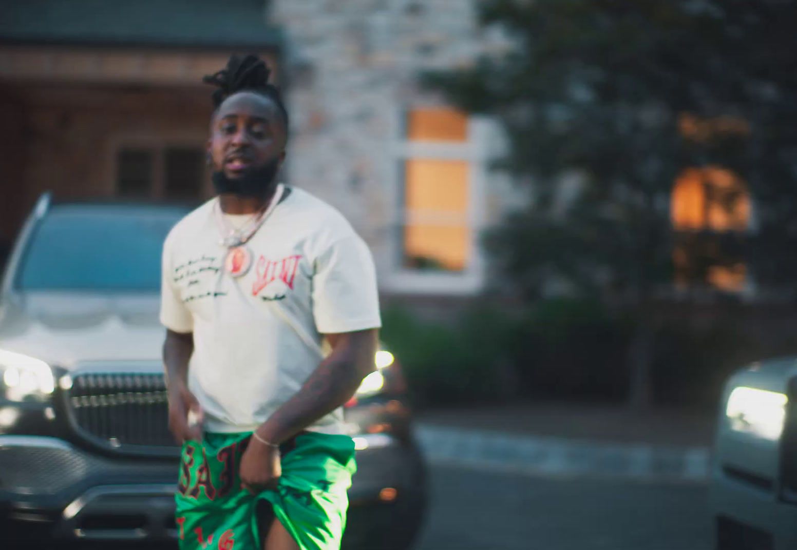 a man in a white shirt and green shorts