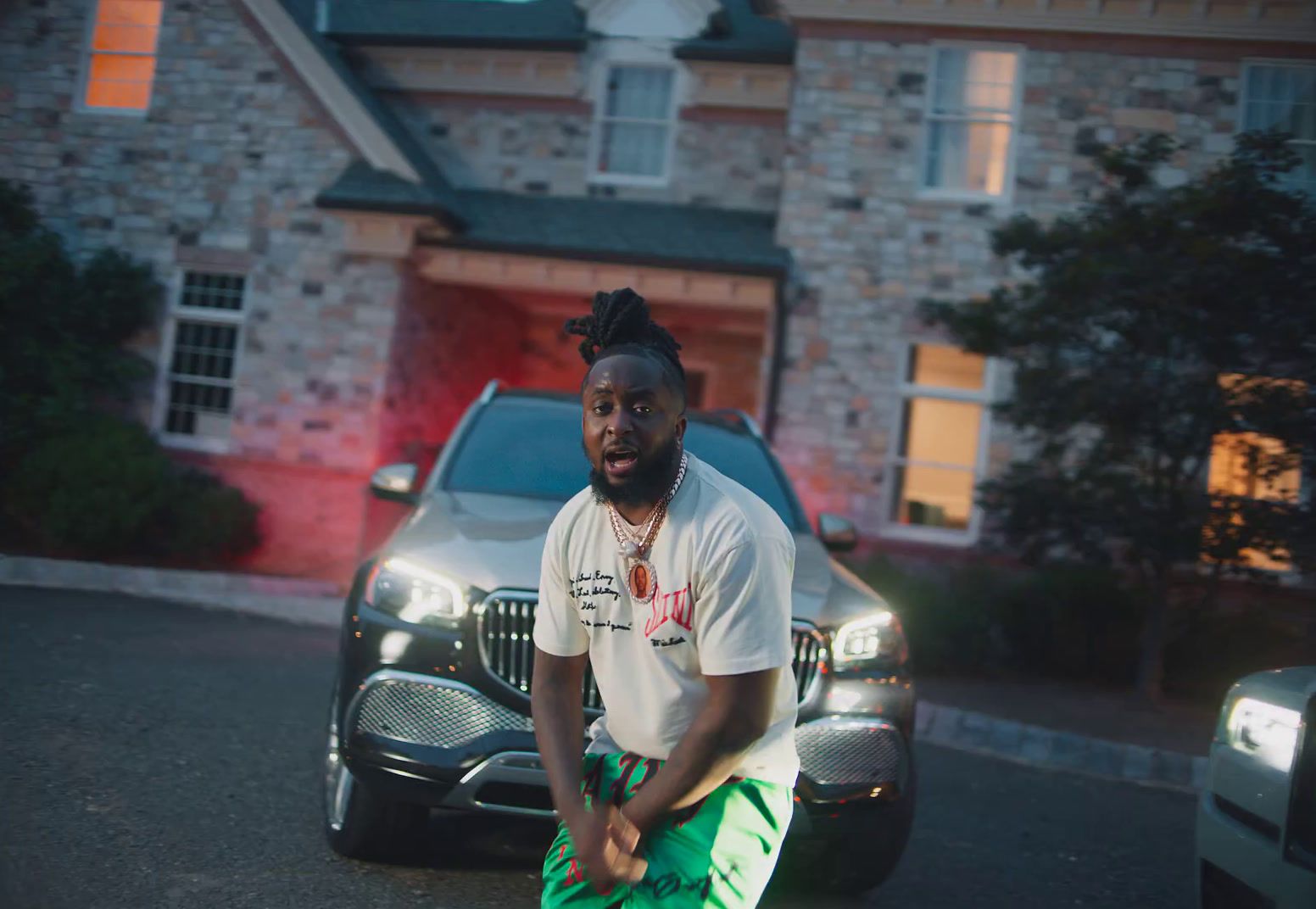 a man sitting on a car in front of a house