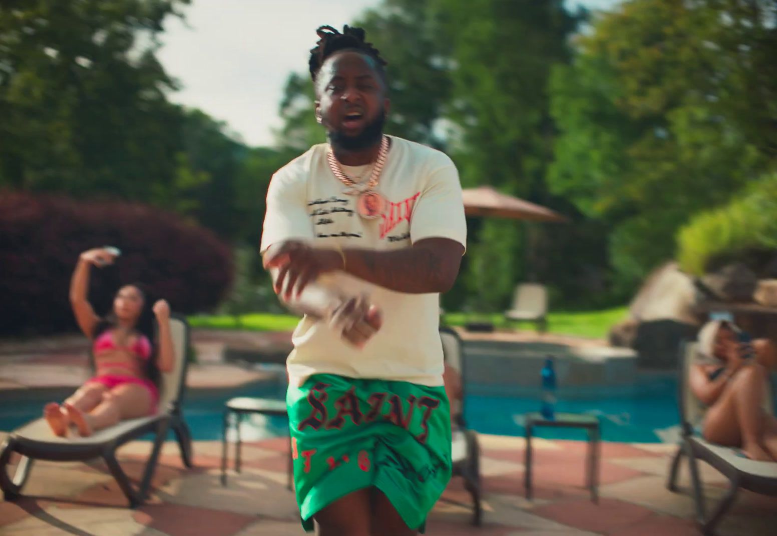 a man standing in front of a pool holding a frisbee