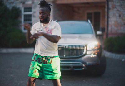 a man in a white shirt and green shorts playing a game of frisbee