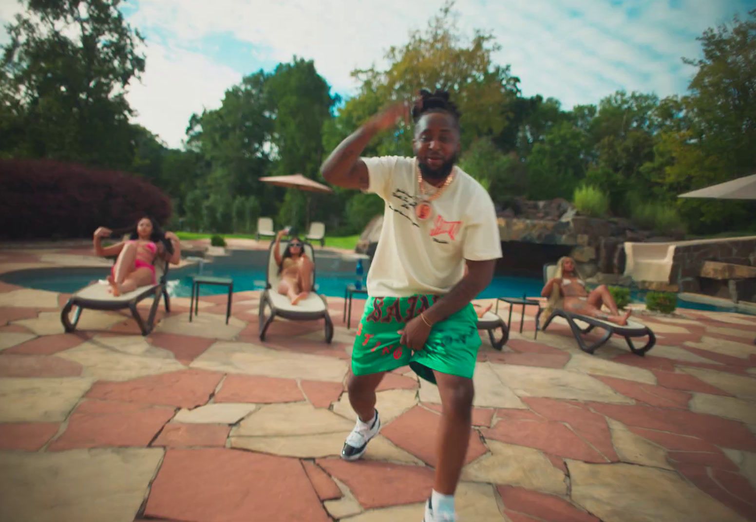 a man standing in front of a pool throwing a frisbee