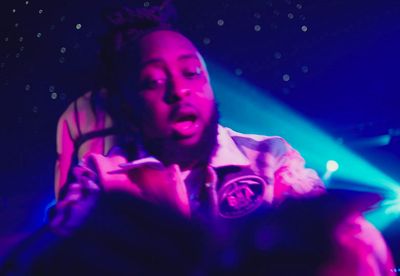 a man with dreadlocks standing in front of a stage