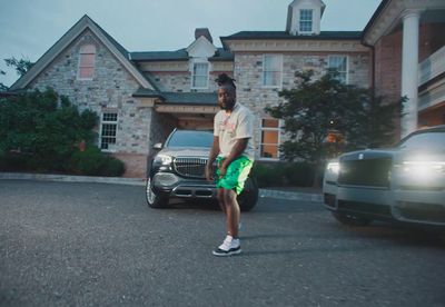 a man standing in front of a car in front of a house