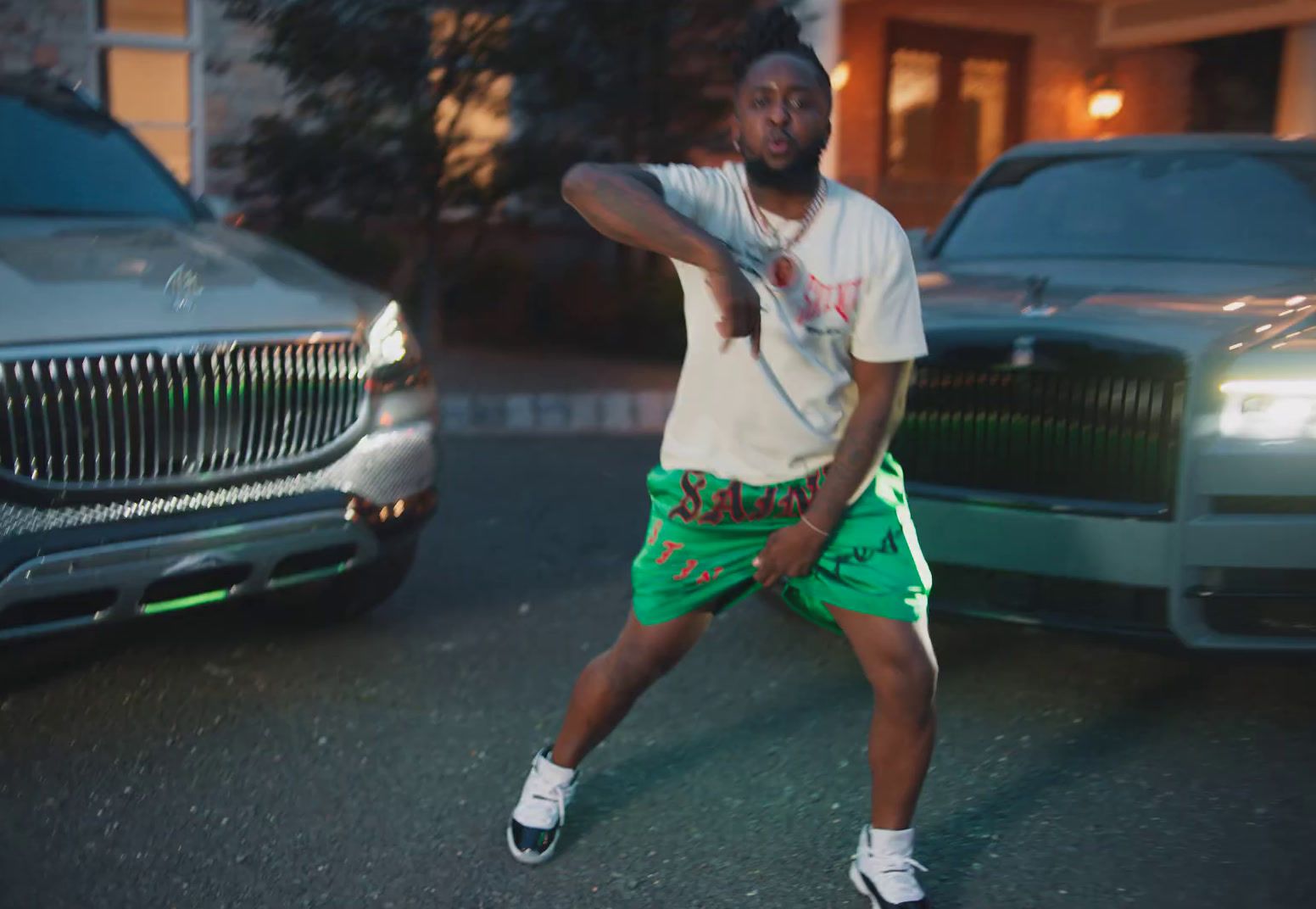 a man in a white t - shirt and green shorts is throwing a fris