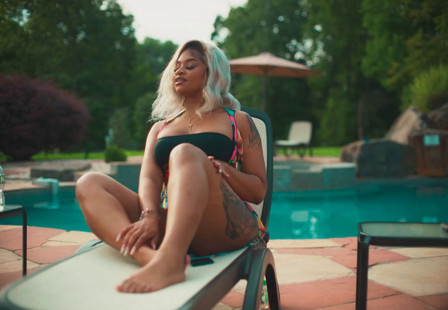 a woman sitting on a chair next to a pool