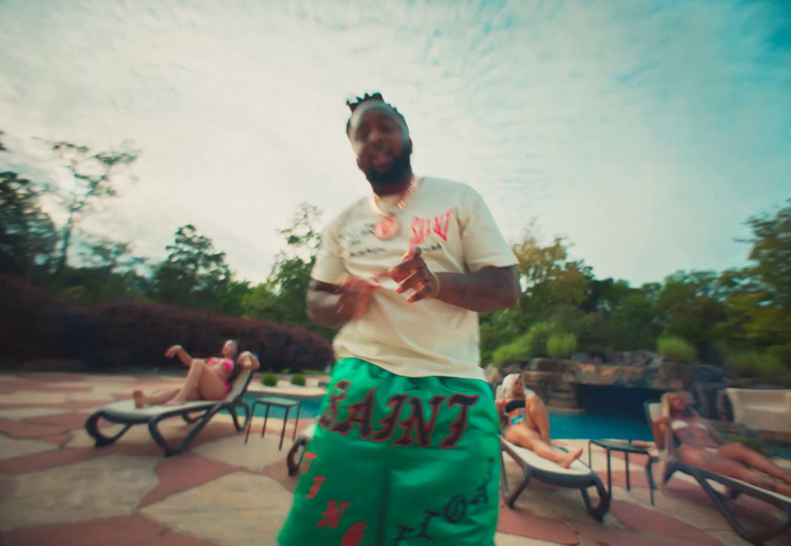 a man in green shorts standing in front of a pool