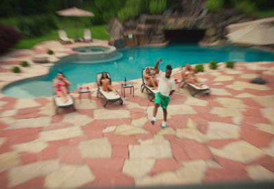 a group of people sitting around a swimming pool