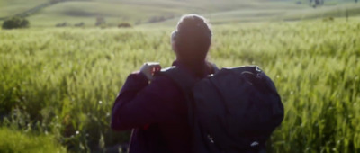 a person standing in a field with a backpack