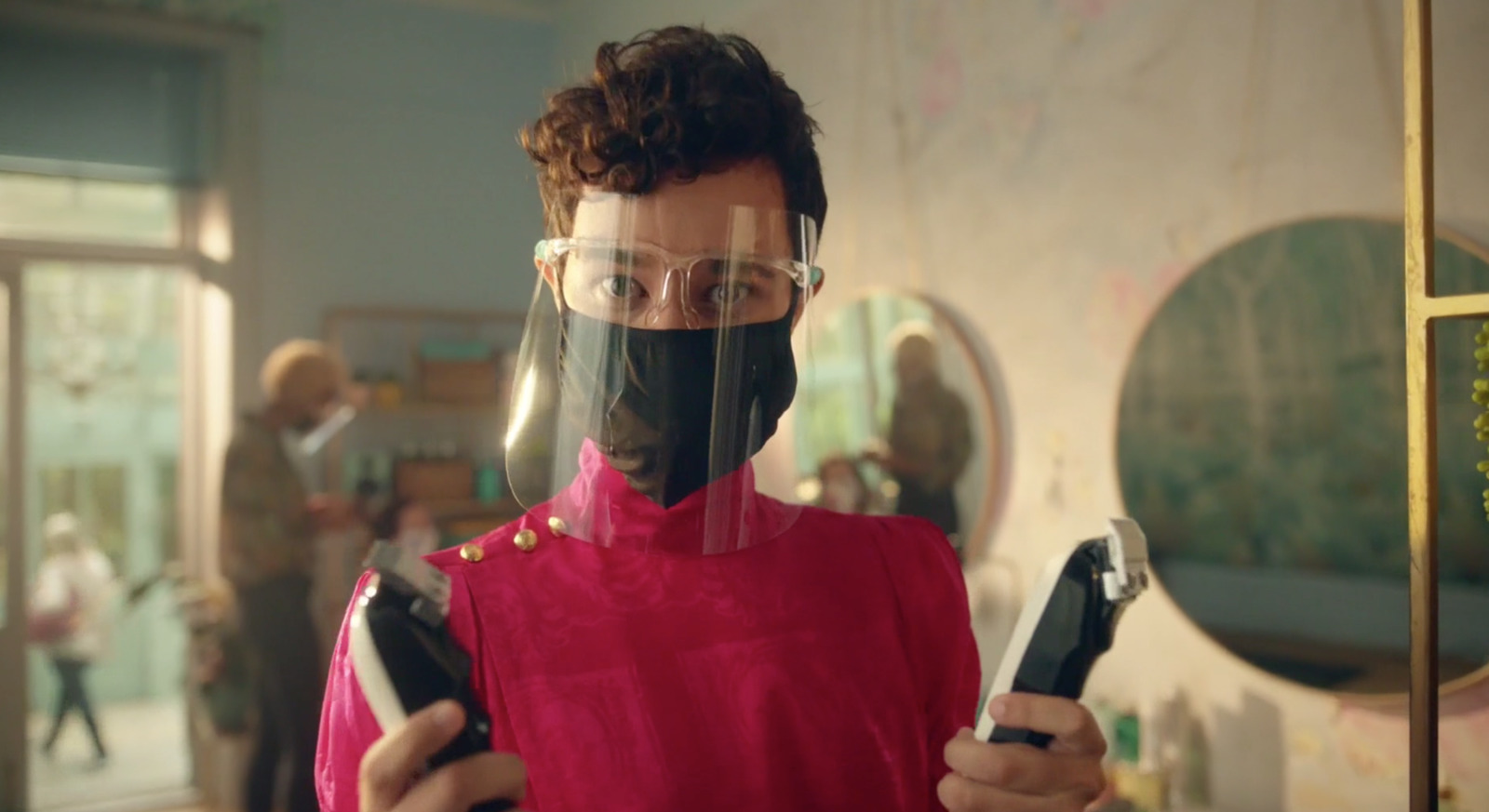 a man in a red shirt holding a pair of scissors