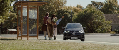 a couple of people walking down a street next to a car