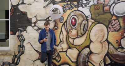 a man standing in front of a graffiti covered wall