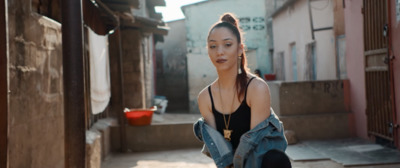 a woman in a black tank top and jean jacket