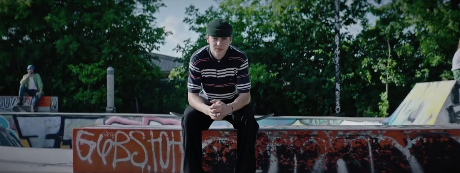 a man sitting on top of a skateboard ramp