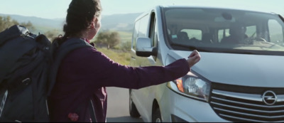 a woman with a backpack standing next to a van