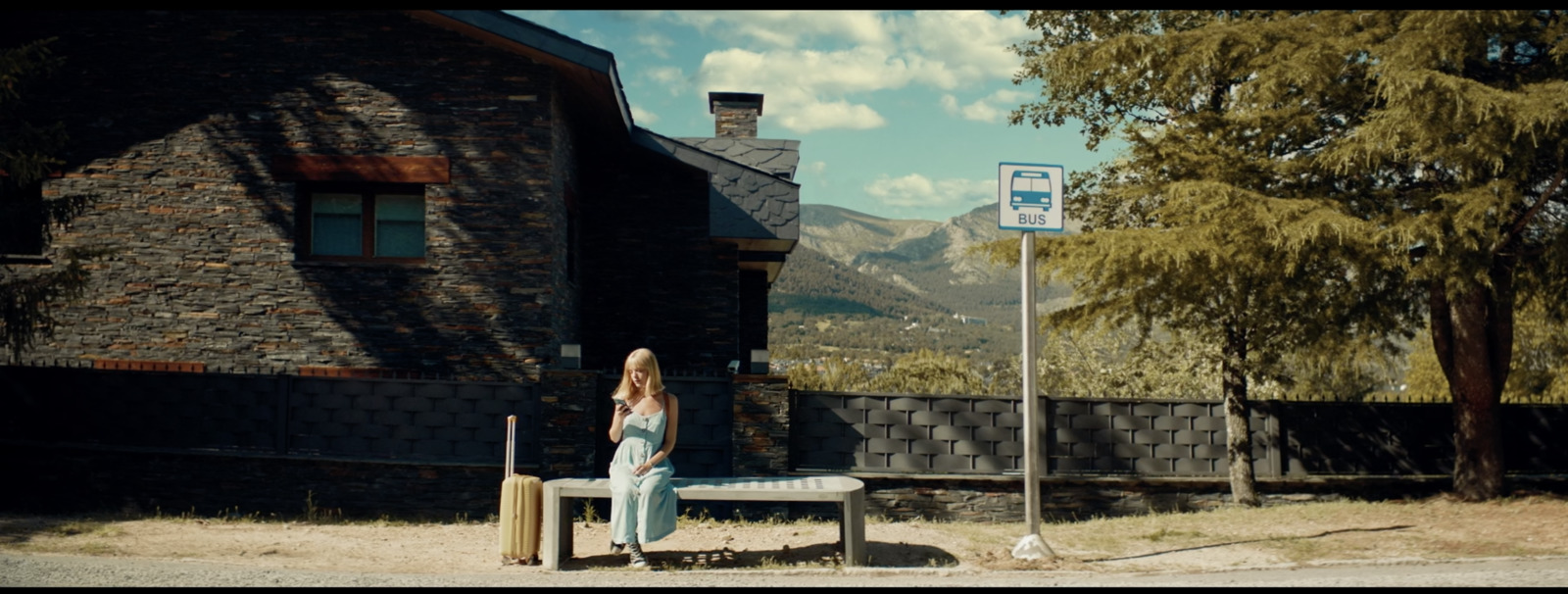 a woman sitting on a bench in front of a building