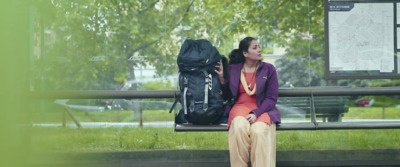 a woman sitting on a bench with a backpack