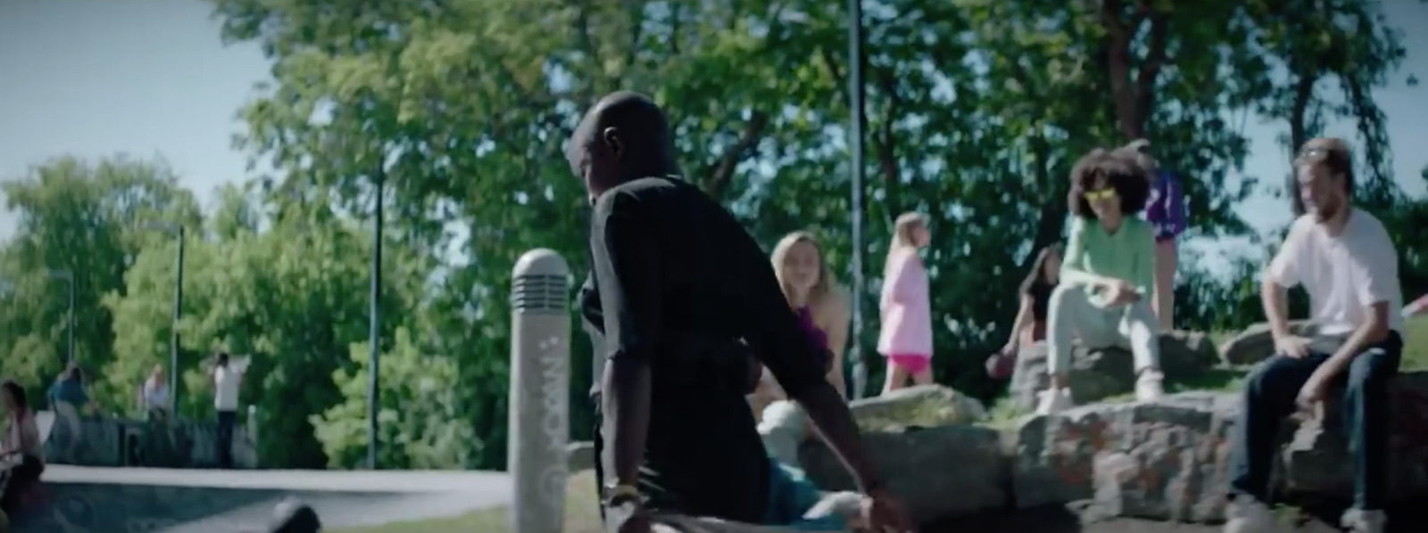 a man riding a skateboard next to a group of people