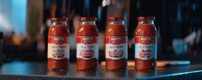 three bottles of tomato sauce sitting on a counter