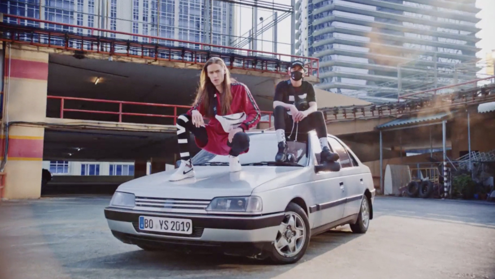 a couple of people standing on top of a car