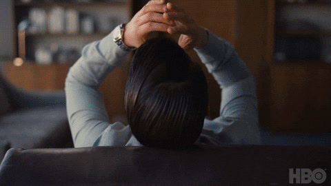 a woman sitting at a table with her head in her hands