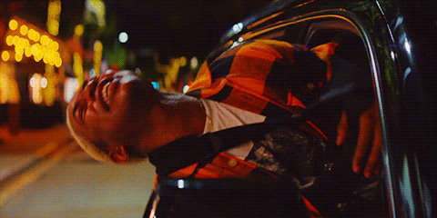 a man leaning out of a car window at night