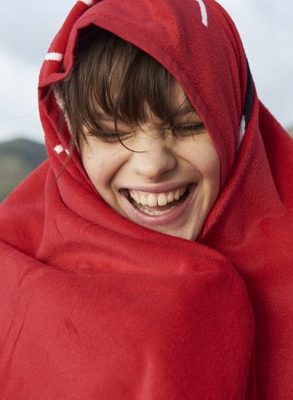 a young boy wearing a red hoodie and smiling