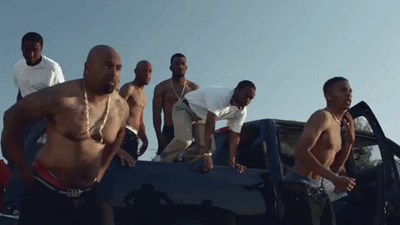 a group of men standing next to each other in front of a car