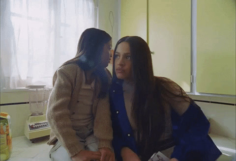 a couple of women standing next to each other in a kitchen