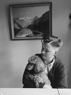 a woman sitting at a table holding a dog