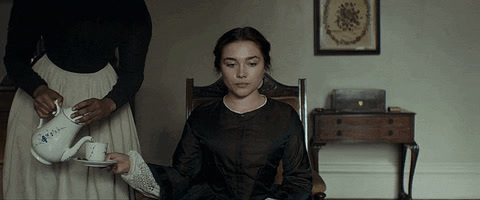 a woman sitting on a chair holding a pitcher