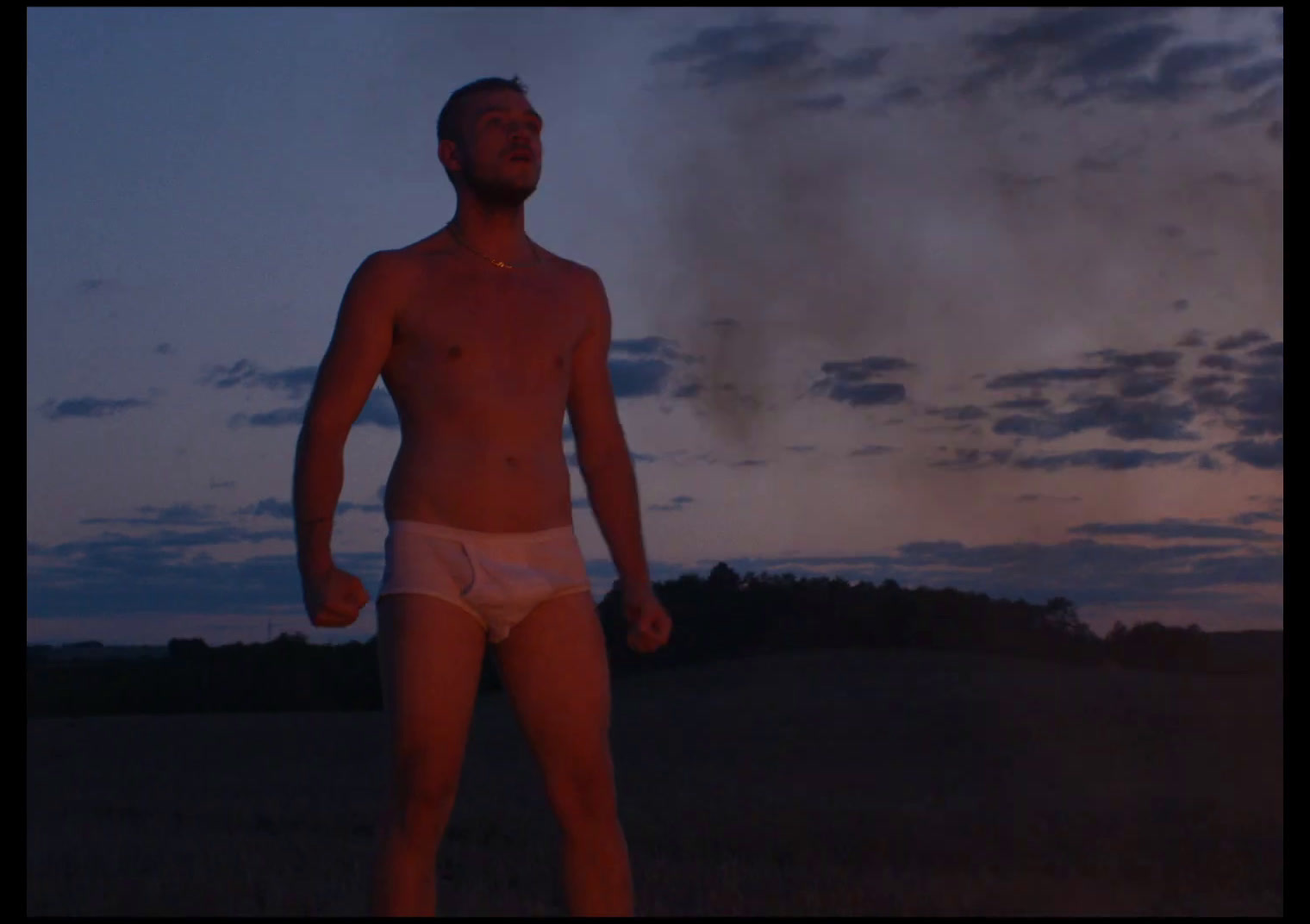 a man in a white underwear standing in a field