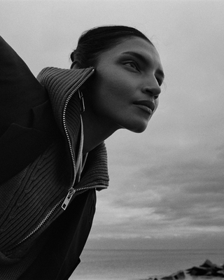 a black and white photo of a woman wearing a sweater