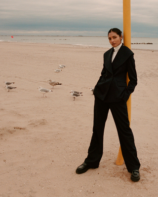 a woman standing next to a pole on a beach