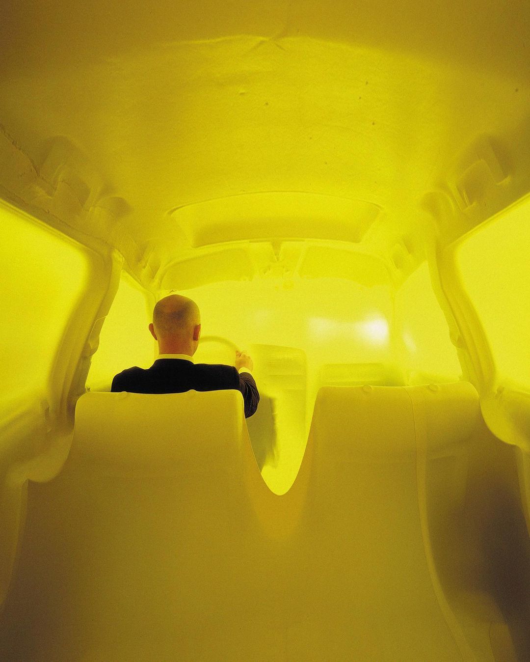 a man in a black shirt is standing in a yellow room