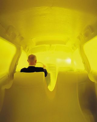a man in a black shirt is standing in a yellow room