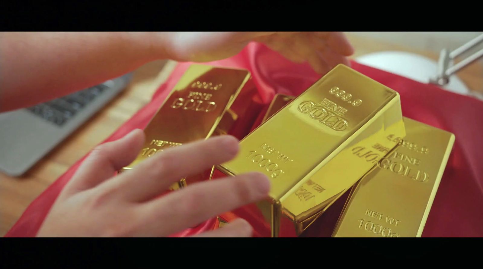 a person holding a bunch of gold bars