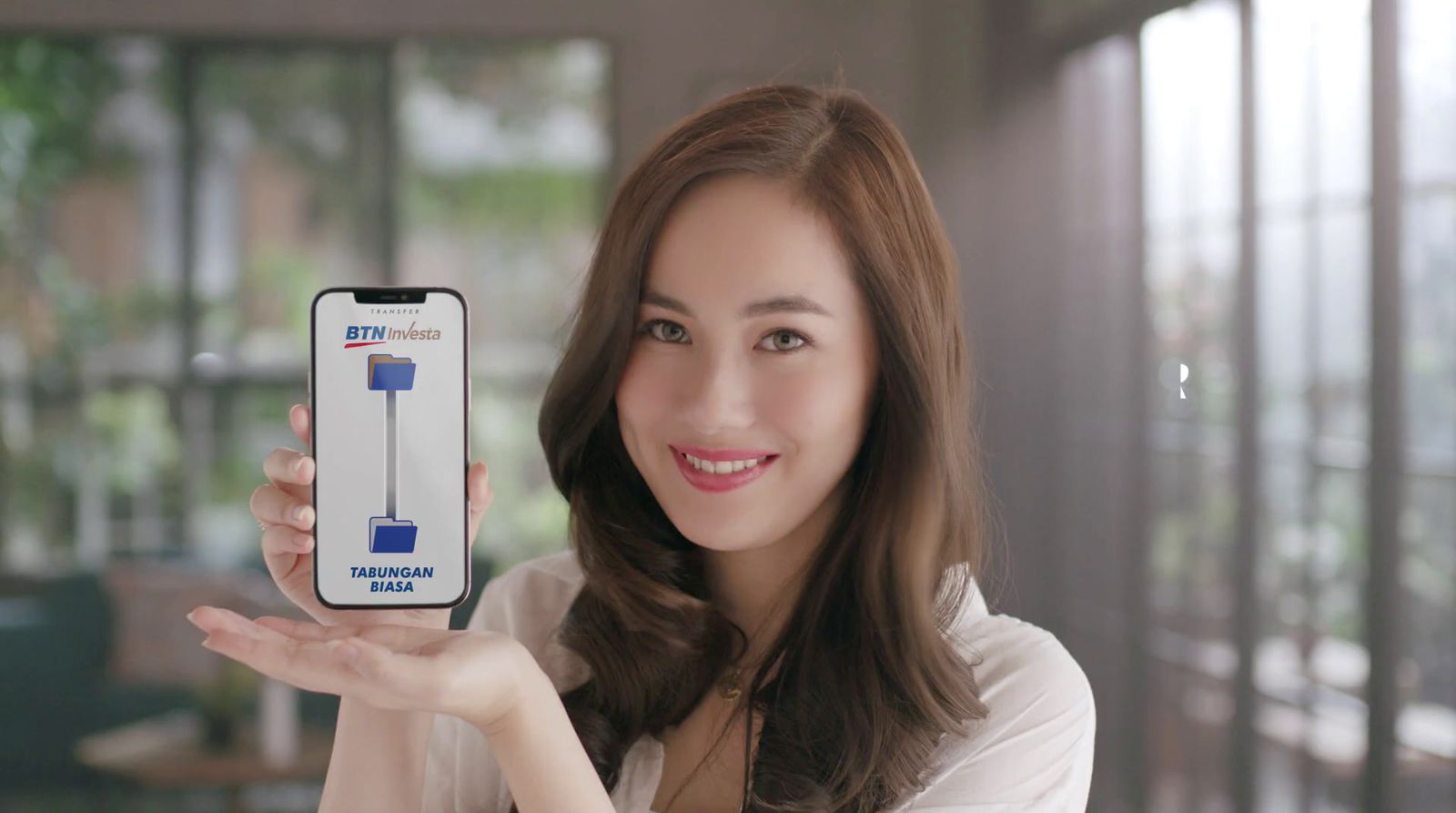 a woman holding up a cell phone in her hand