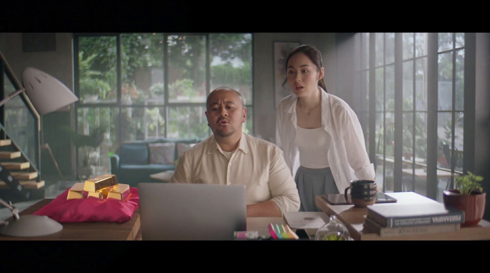 a man sitting at a desk next to a woman