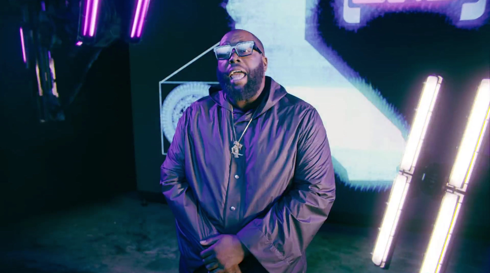 a man standing in front of a wall with neon lights