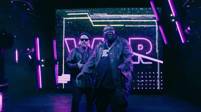 two men standing in front of a neon sign