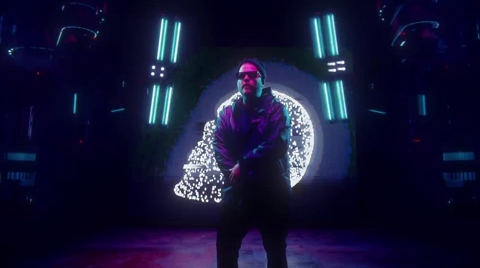 a man standing in a dark room with neon lights