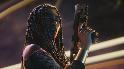 a woman with dreadlocks holding a gun