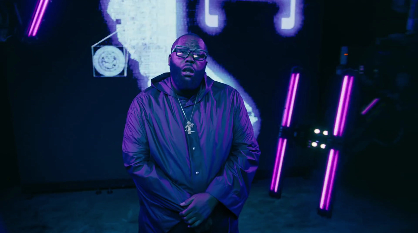 a man standing in front of a wall with neon lights