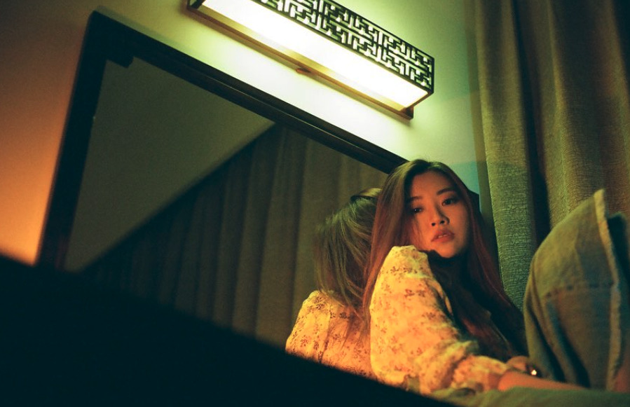 a woman sitting in front of a mirror in a room