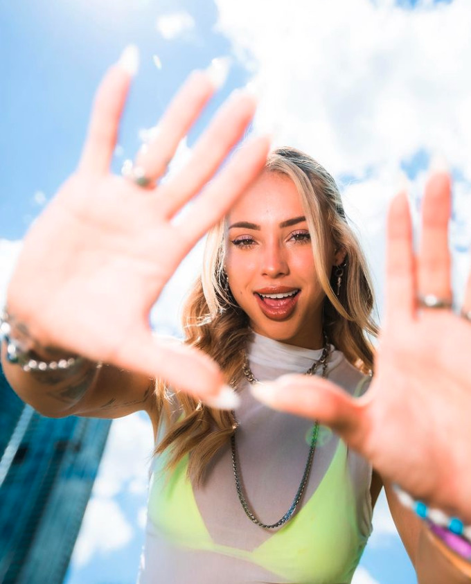 a woman in a yellow top making a hand gesture