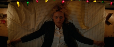 a woman laying in a bed with christmas lights