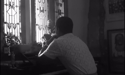 a man sitting at a piano in front of a window